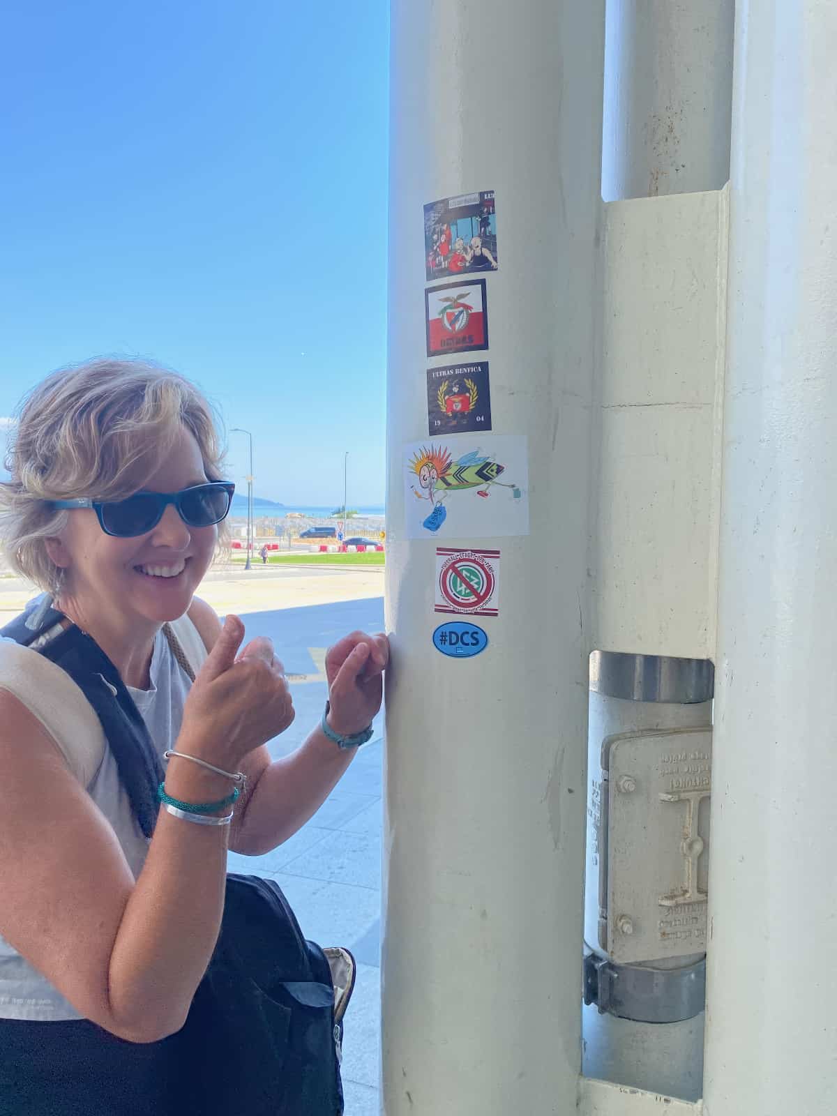 Amy Stearns thumbs up with #DCS sticker on a light pole